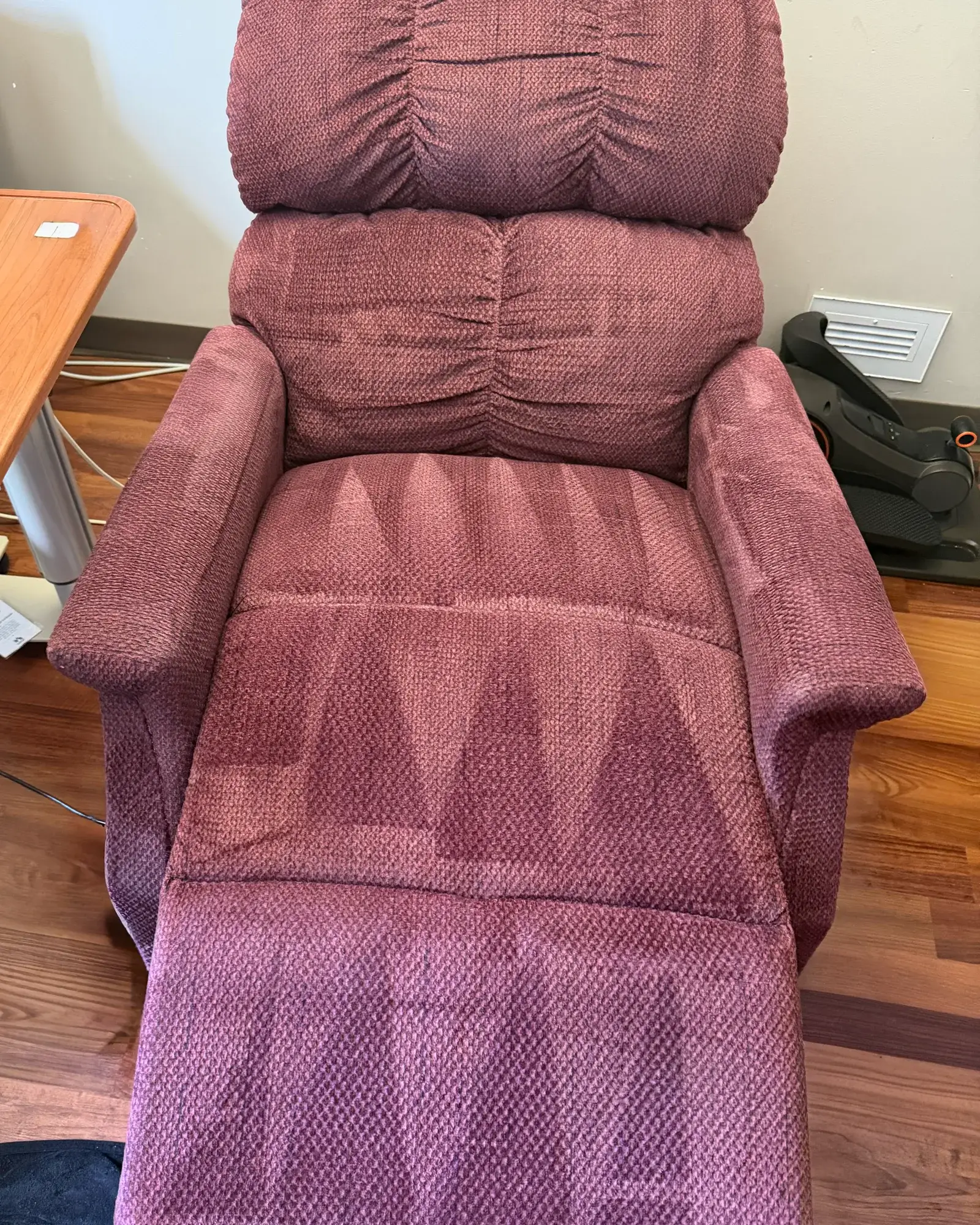 A mauve fabric recliner after cleaning, wand strokes still visible across the seat and footrest.